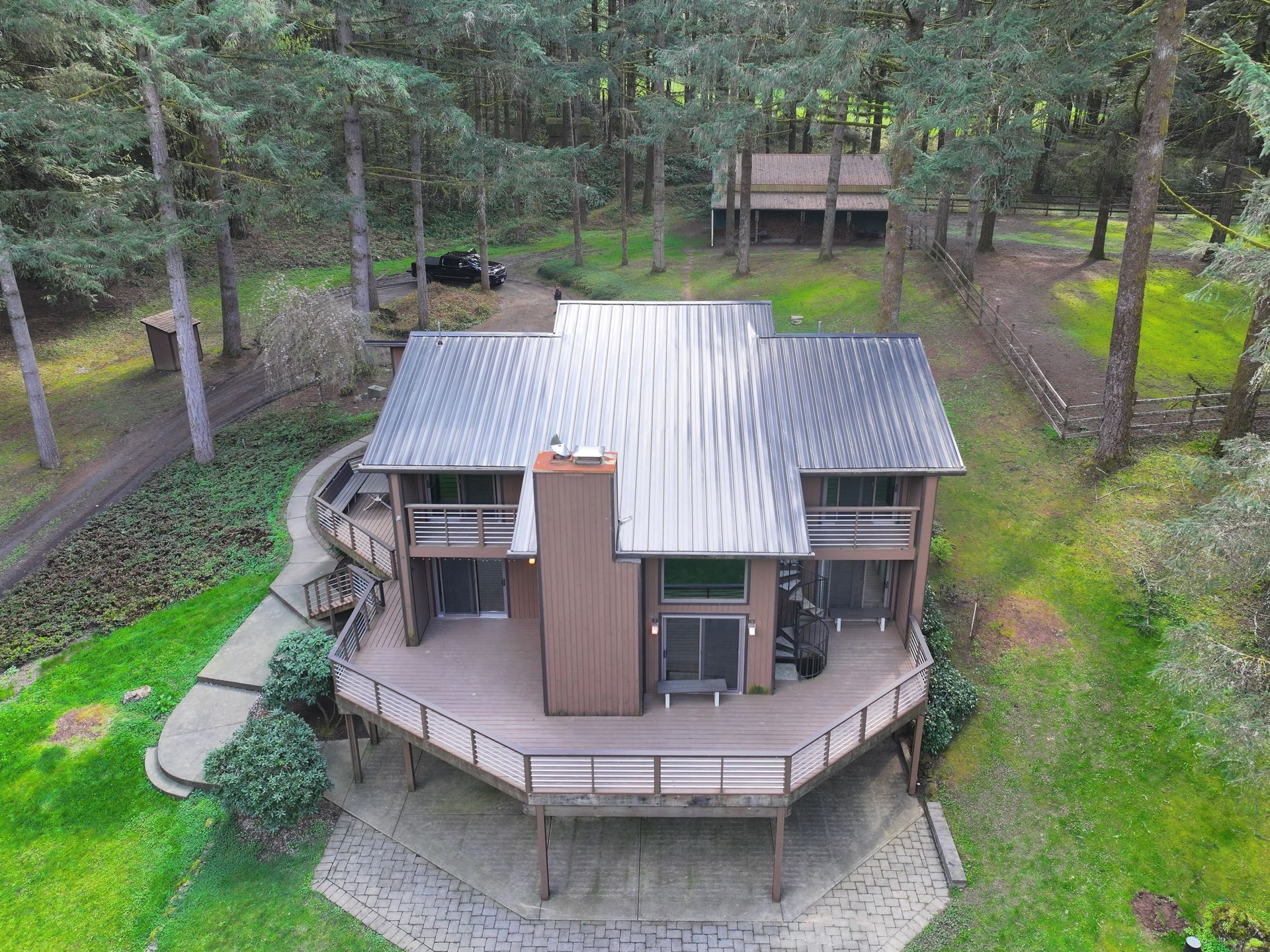 An aerial view of a house in the middle of a forest