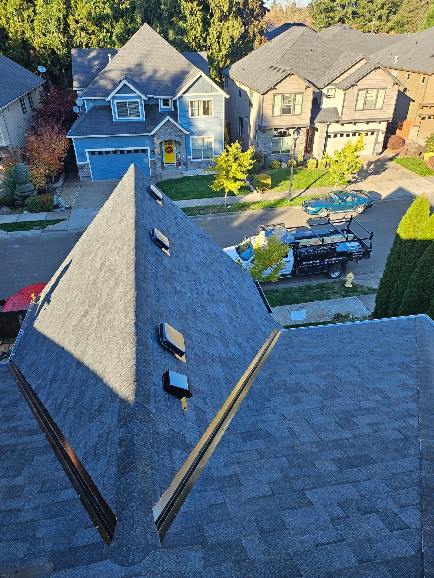 An aerial view of a roof of a house in a residential neighborhood.