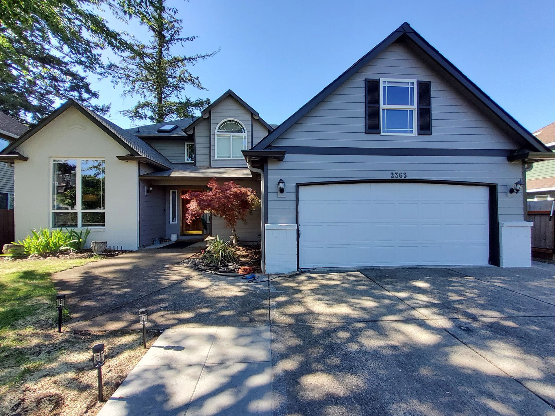 A house with a white garage door and black shutters