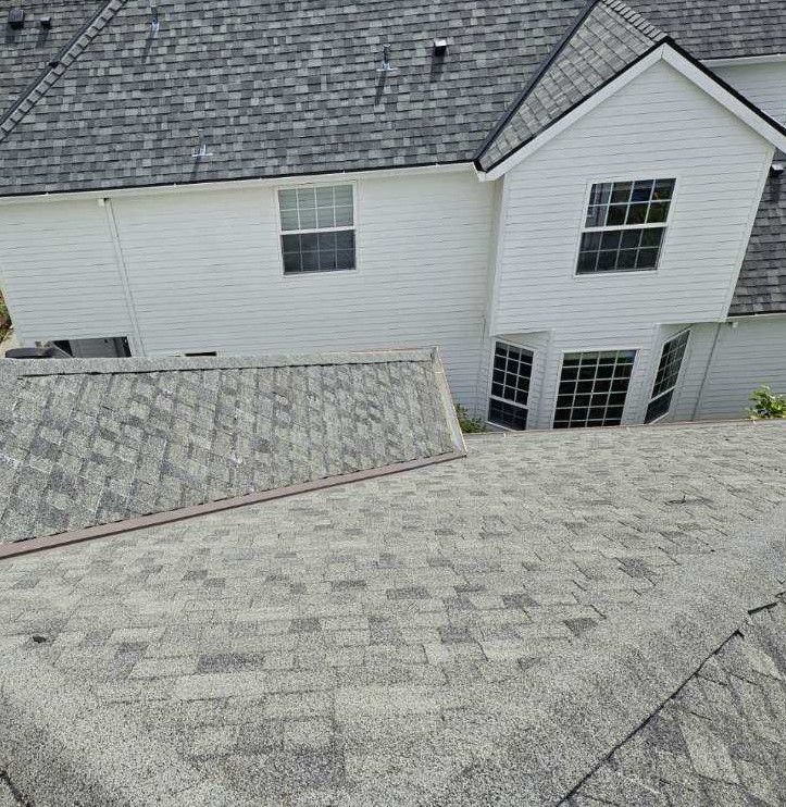 The roof of a house with a gray shingle roof.