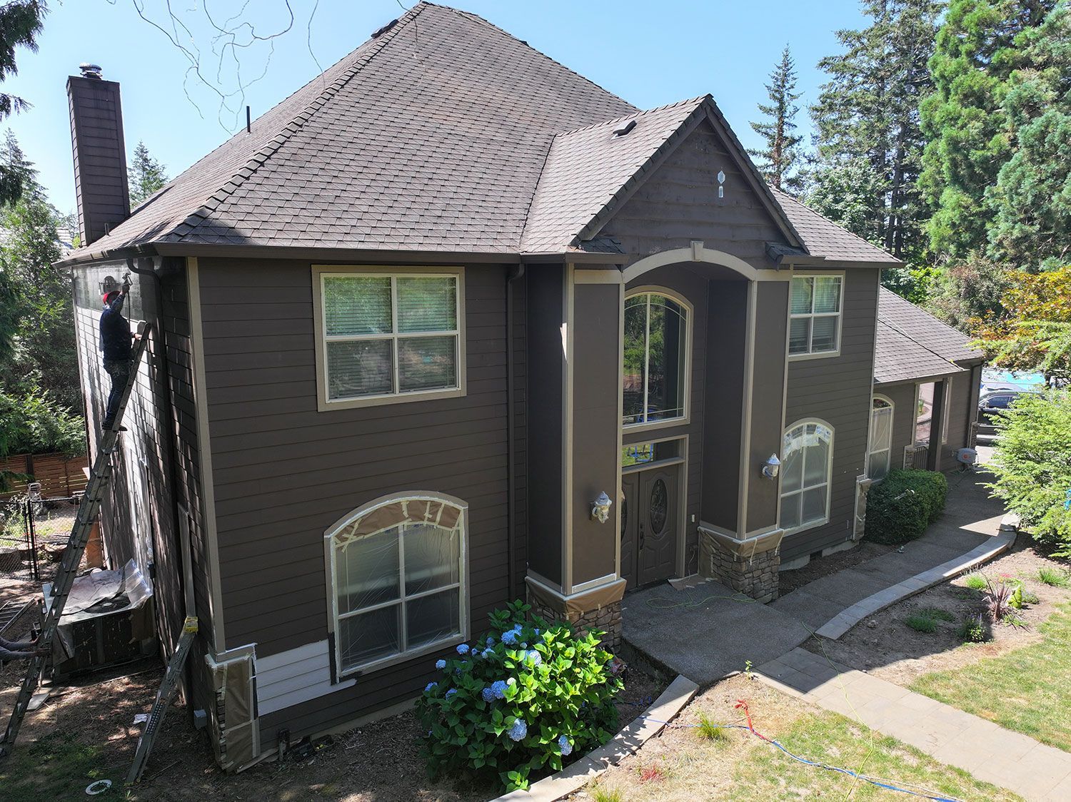 A large house with a lot of windows is being painted