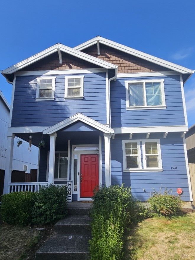 A blue house with a red door and white trim