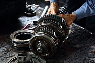 A man is working on a gearbox on a table.