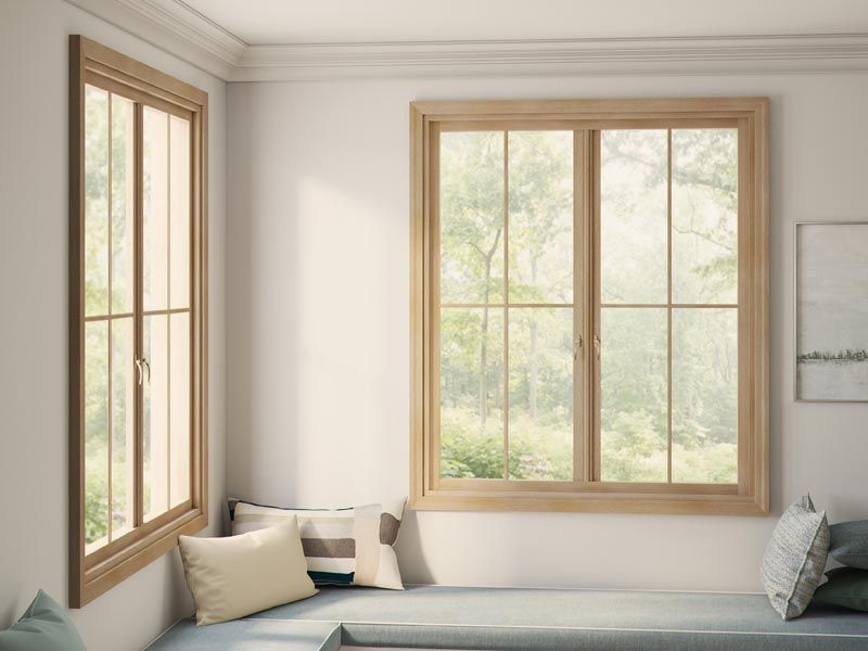 A living room with a window seat and two windows.