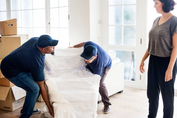 Three movers carrying boxes into a room, representing a local moving company's services.