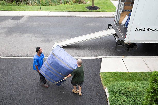 Office workers moving boxes and furniture in a busy office environment