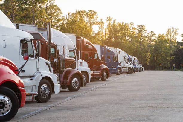 . Several semi trucks parked in a row, designated for long-distance moving services.


