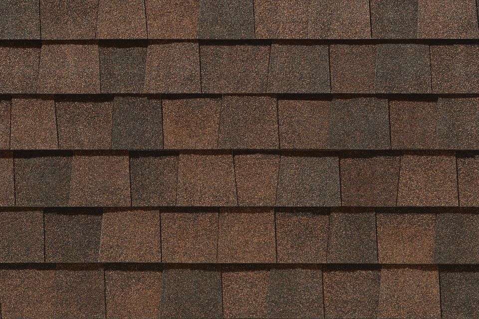 A close up of a roof with brown shingles.