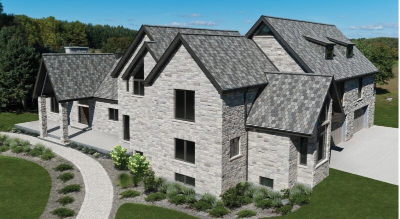 A multi-level stone house with a gray roof, a winding stone path, and green landscaping under a blue sky.