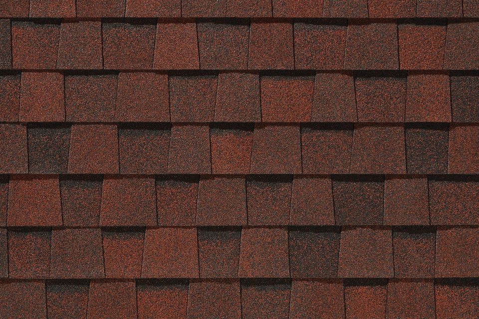 A close up of a roof with red shingles.