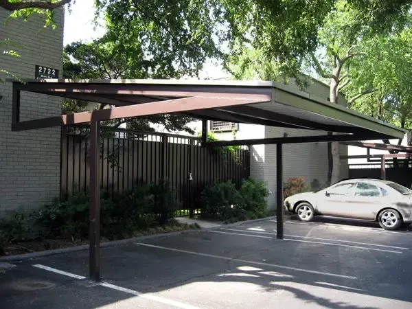 Carport with brown metal frame over a parking spot, protecting a parked white car.