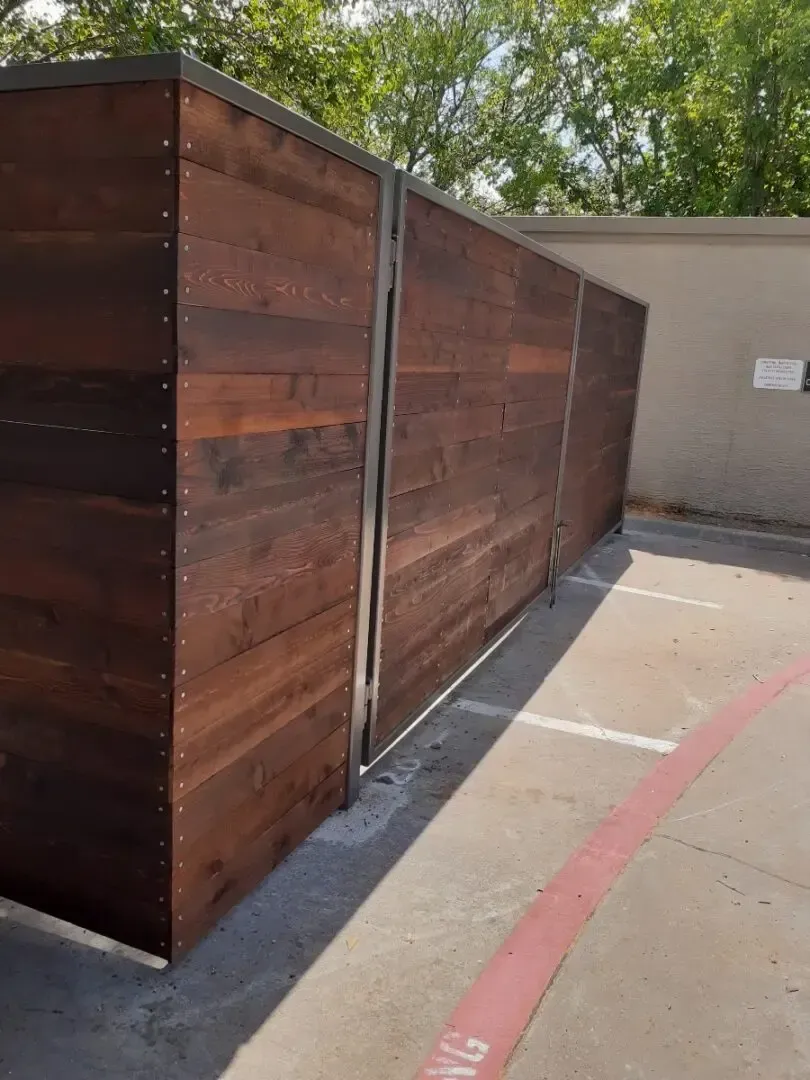 Wooden fence with metal posts and a painted parking space.