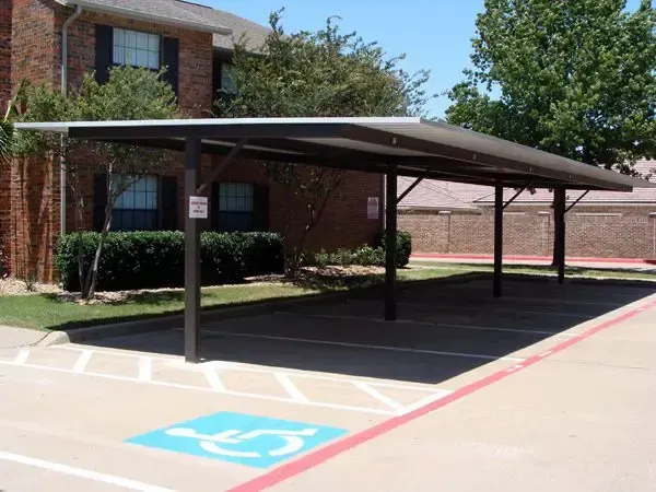 Carport with accessible parking space; brown frame, blue handicap symbol.