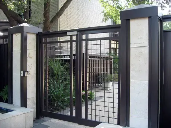 Black metal gate with square grid design between stone pillars.