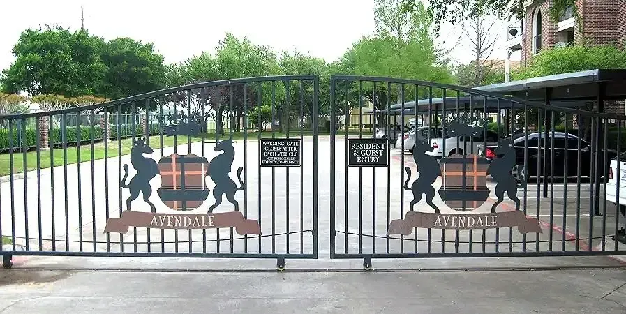 Black wrought-iron gates with a crest featuring lions, a barrel, and the name