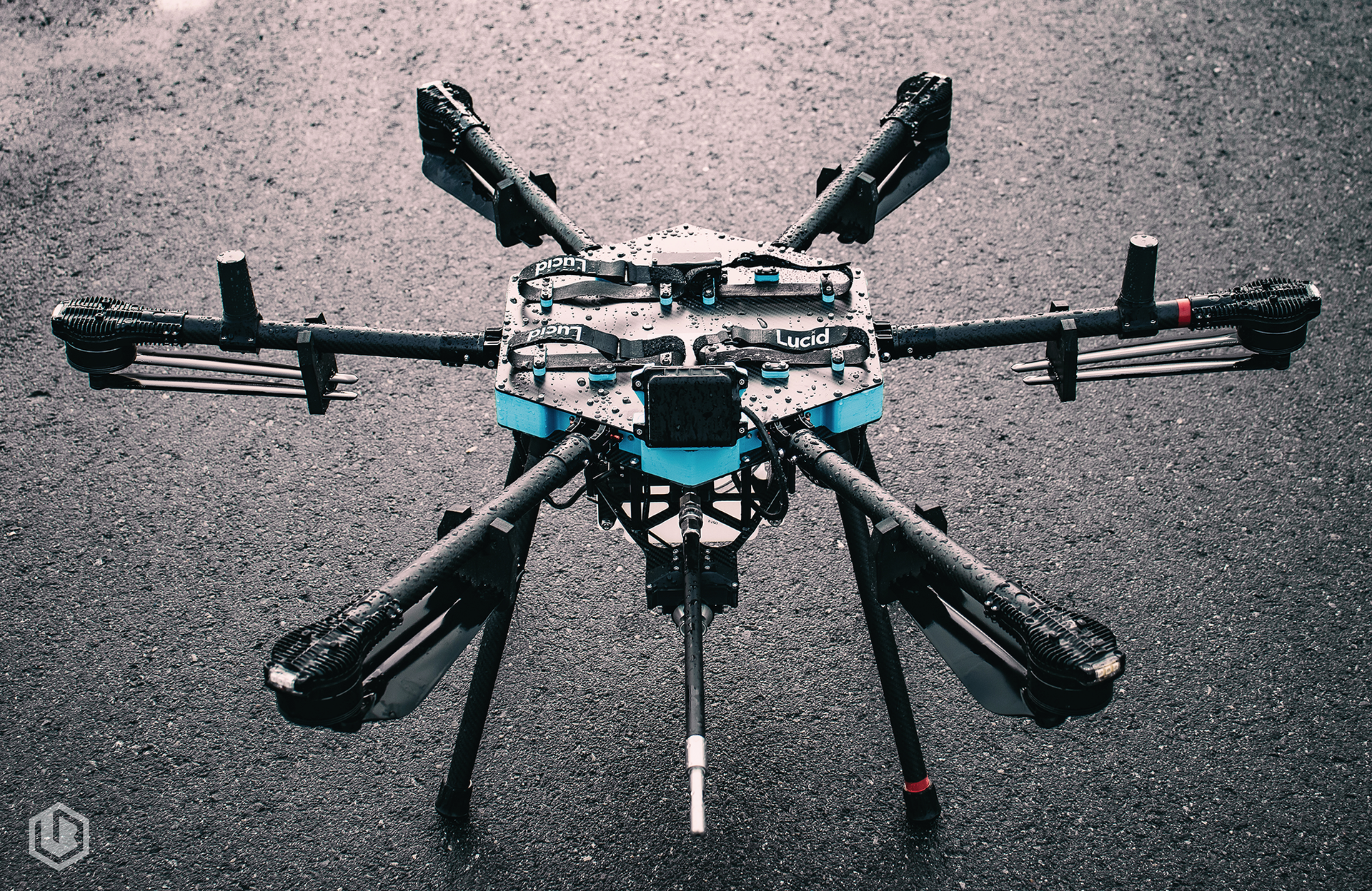 Octocopter drone with blue and black frame on a rough gray surface