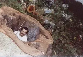 A man is laying in a hole in the ground.
