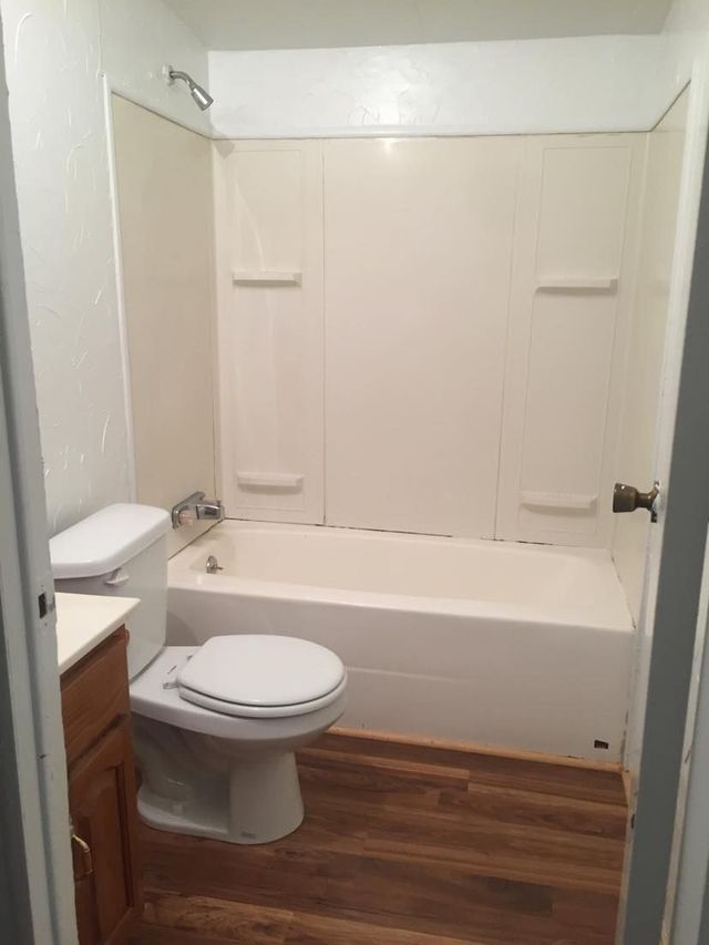 A bathroom with a toilet , bathtub and shower.