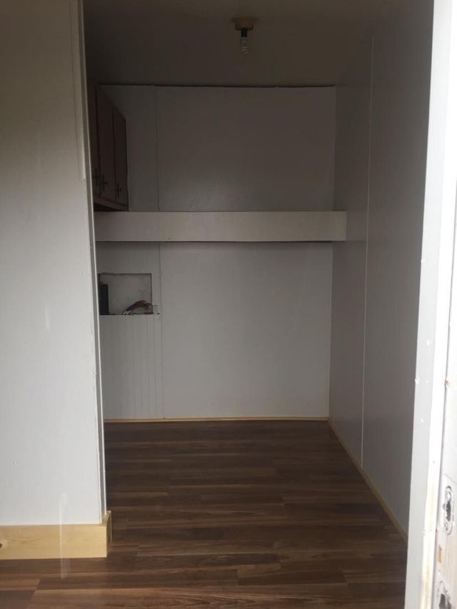 An empty room with wooden floors and white walls.