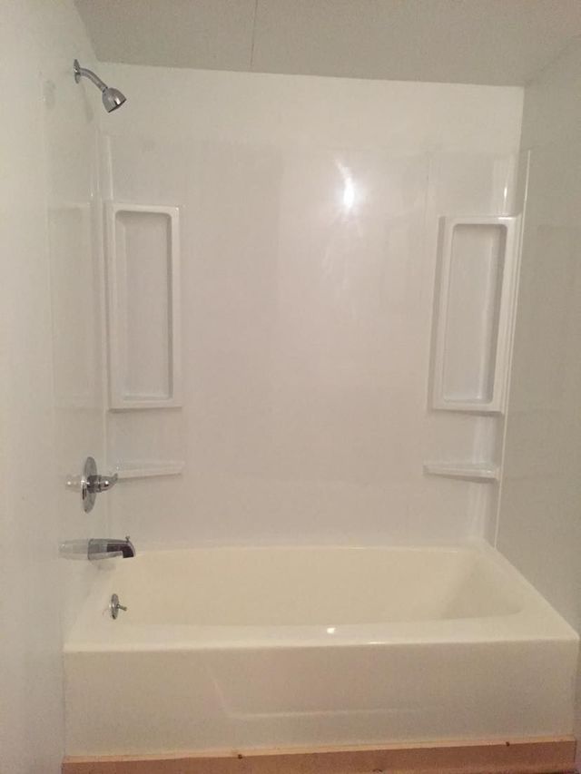 A bathroom with a bathtub and a shower.