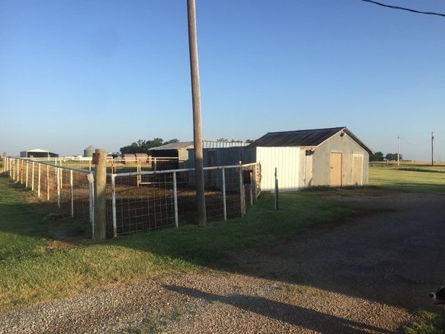 A fenced in area with a shed in the background