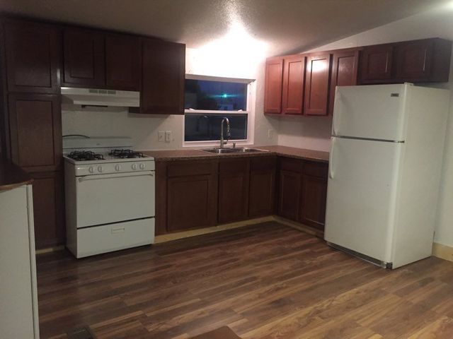 A kitchen with a stove a refrigerator and a sink