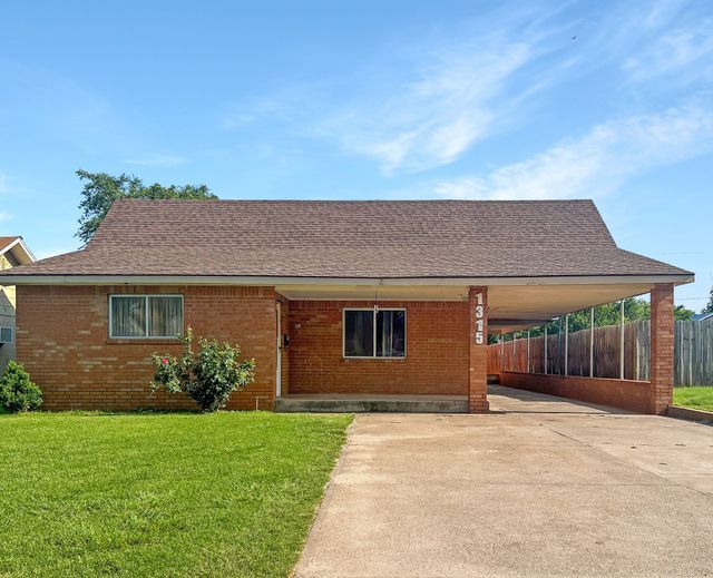 A brick house with a driveway leading to it