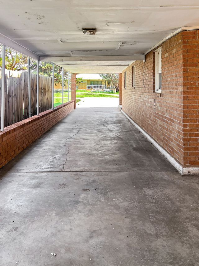 A long concrete walkway leading to a brick building.