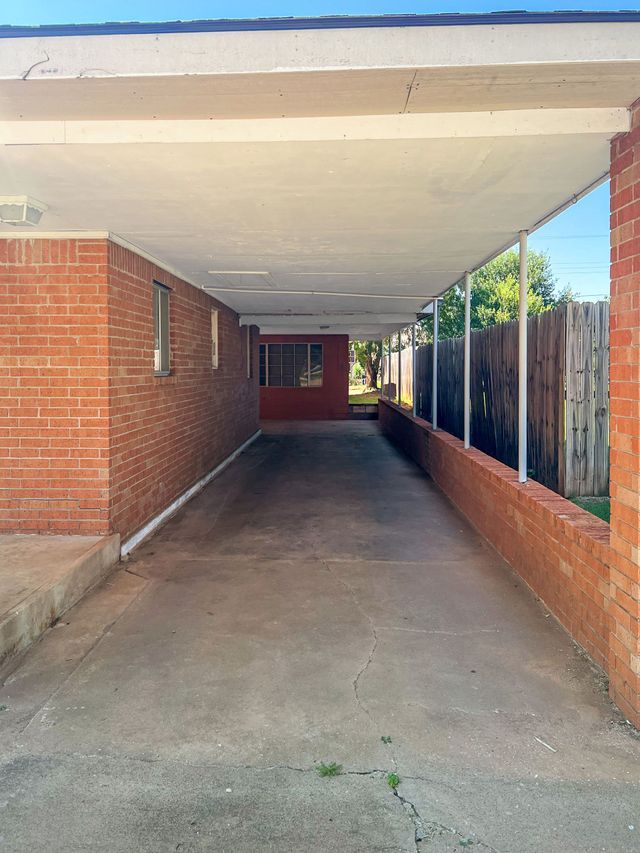 A brick building with a covered driveway leading to it.