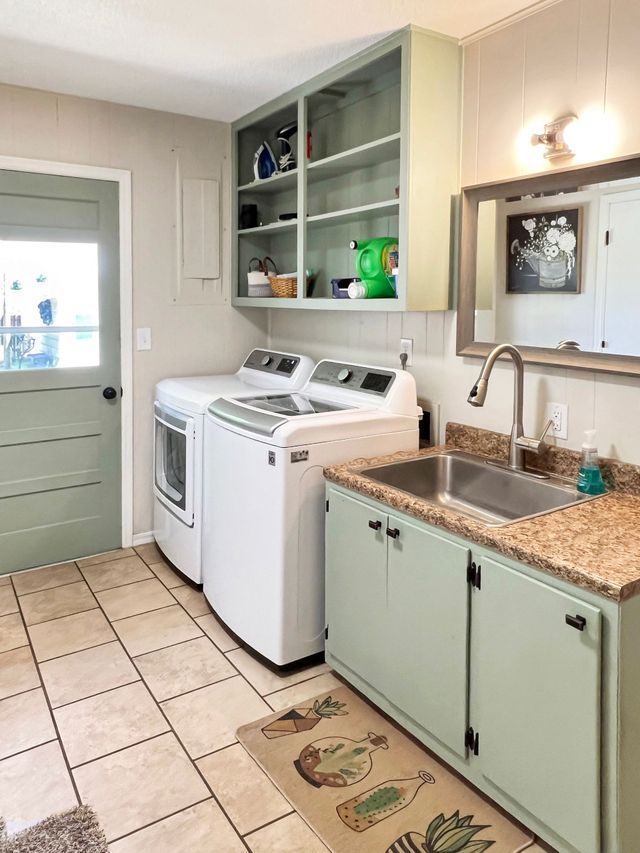 A laundry room with a washer and dryer and a sink