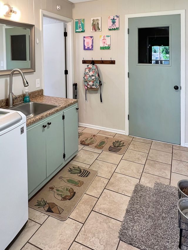 A laundry room with a washer and dryer and a sink