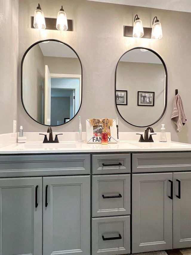 A bathroom with two sinks and two mirrors.