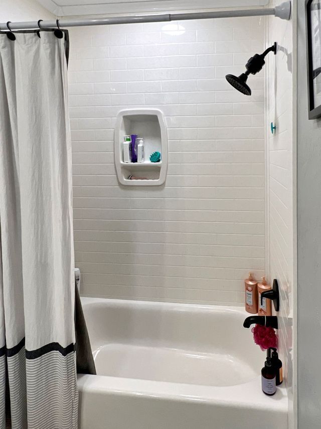A bathroom with a bathtub and a shower curtain.