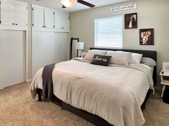 A bedroom with a king size bed and a ceiling fan