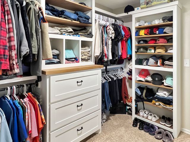 A walk in closet filled with lots of clothes and hats.
