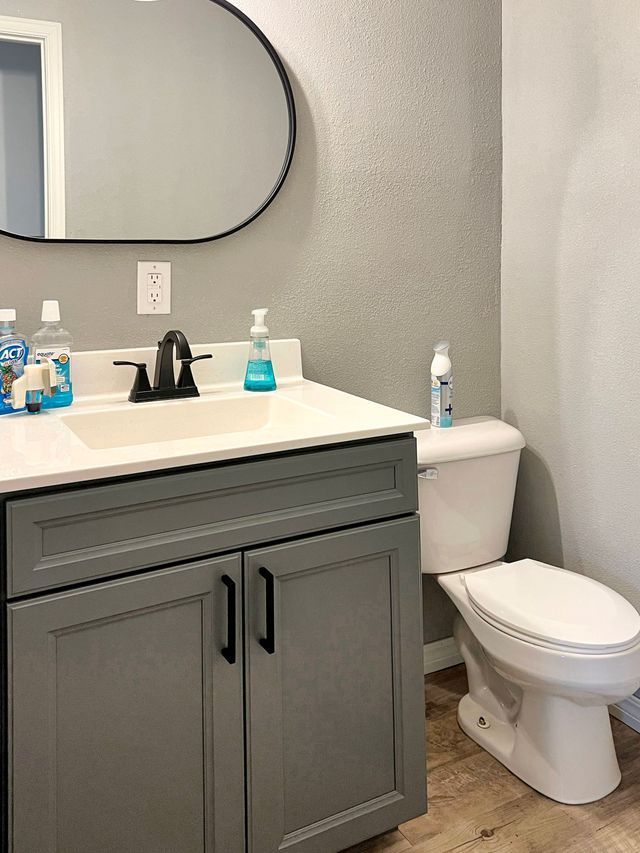 A bathroom with a sink , toilet and mirror.