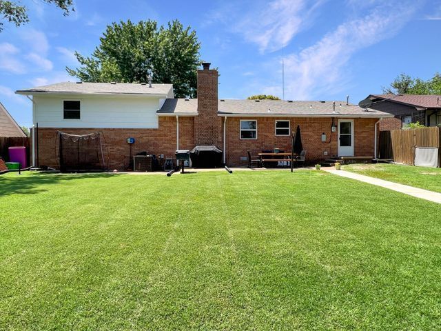 A brick house with a large lawn in front of it