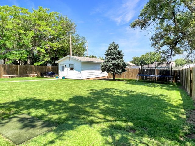 There is a trampoline in the backyard of a house.