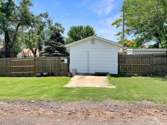 A white garage with a wooden fence around it