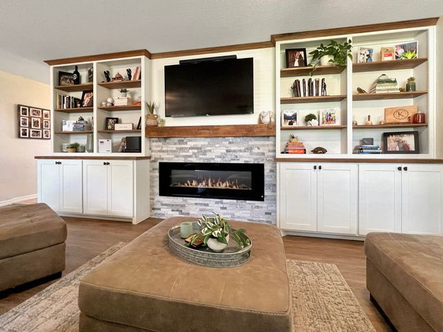 A living room with a fireplace and a flat screen tv.