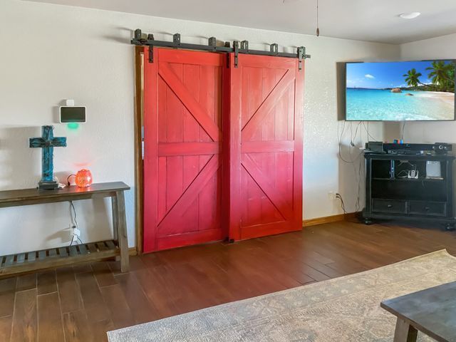 A living room with red sliding barn doors and a flat screen tv.