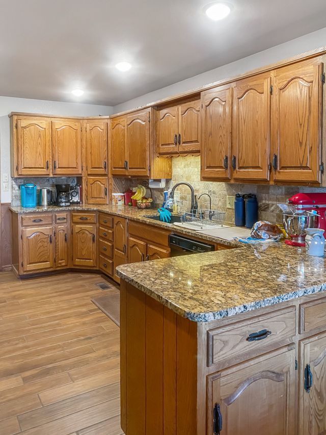 A kitchen with wooden cabinets and granite counter tops.