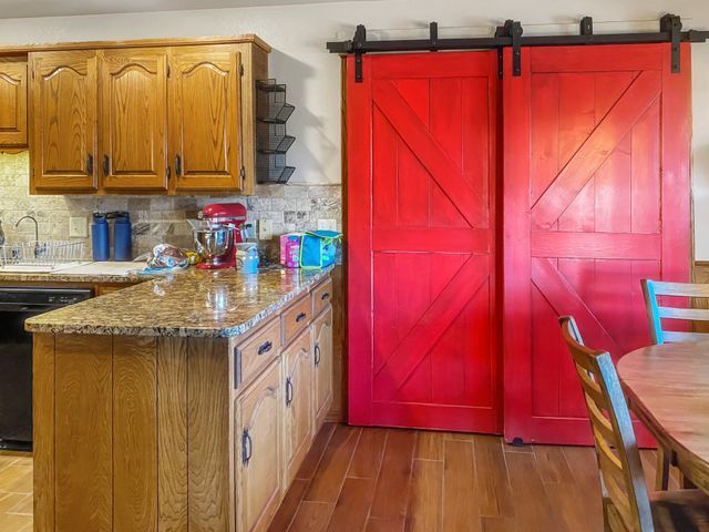A kitchen with red sliding barn doors and wooden cabinets.