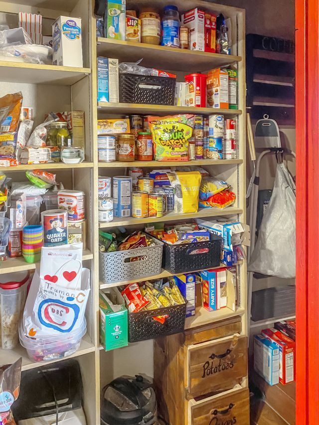 A pantry filled with lots of food and a red door.
