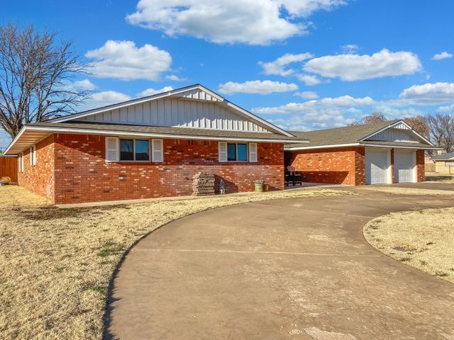 A brick house with a driveway leading to it