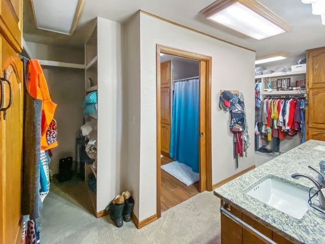A bathroom with a walk in closet and a sink