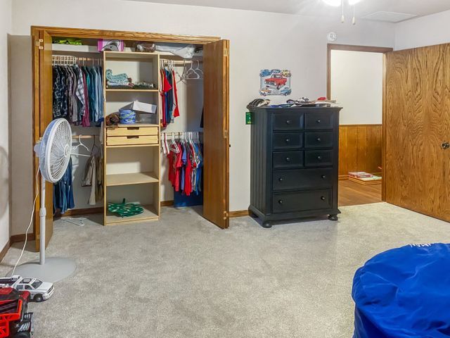 A bedroom with a closet , dresser , and blue bean bag chair.