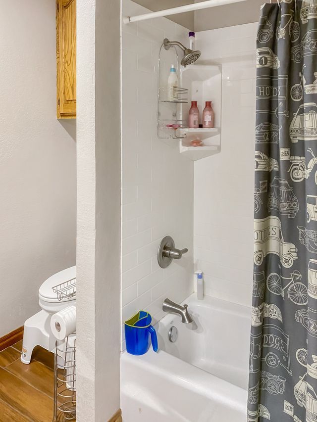 A bathroom with a bathtub , toilet and shower.