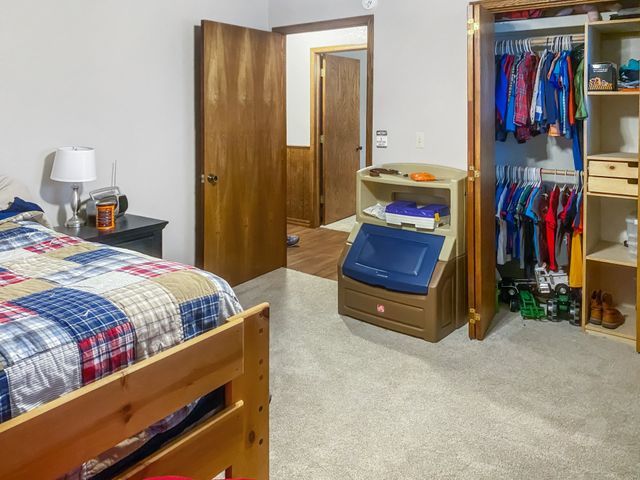 A bedroom with a bunk bed and a closet filled with clothes.