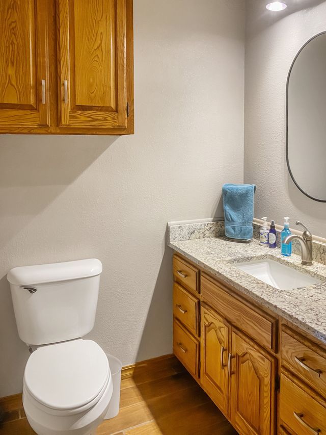 A bathroom with a toilet , sink and mirror.